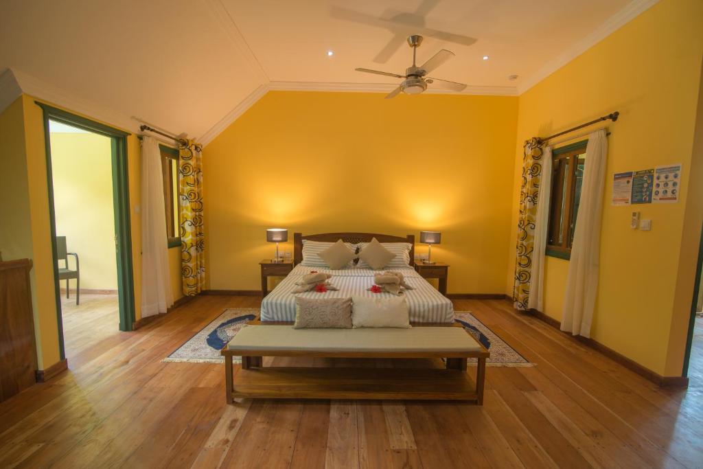 拉迪格岛Pension Michel Villa Roche Bois的一间卧室设有一张黄色墙壁的大床