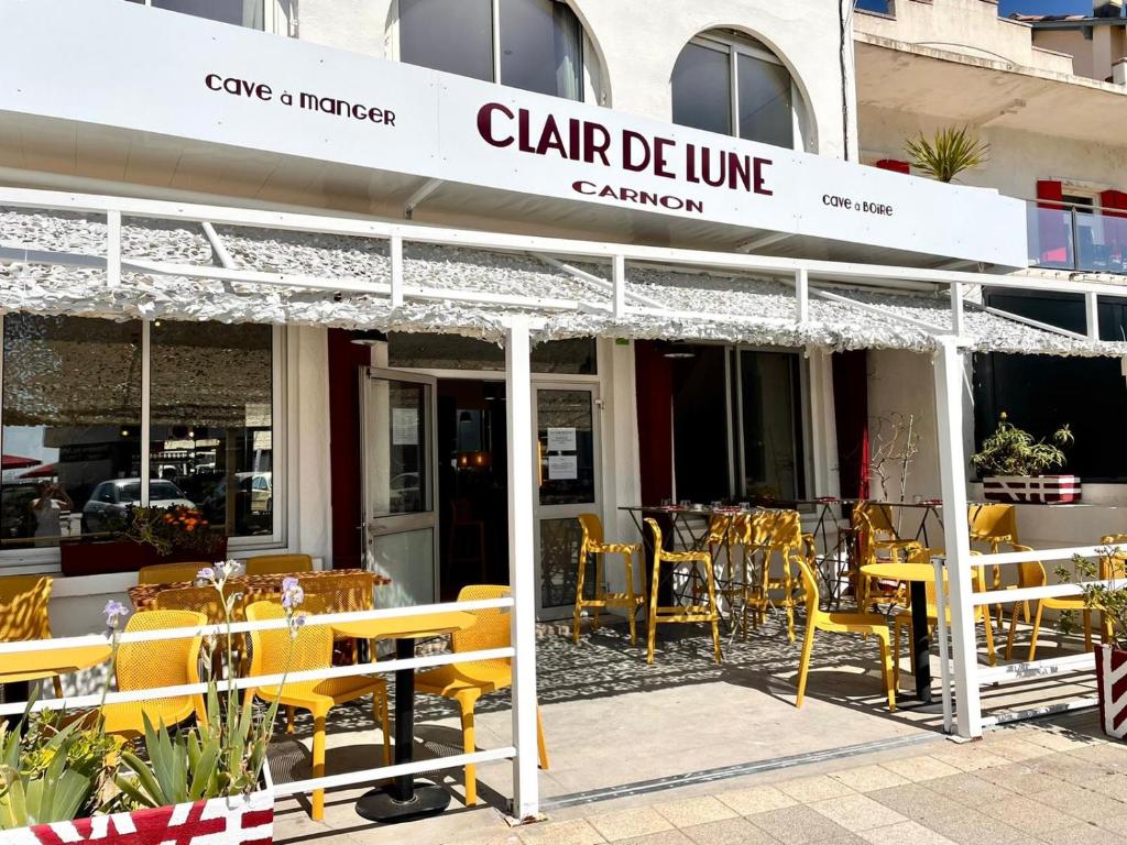 莫吉奥Hôtel Clair de Lune的餐厅前面设有黄色的桌椅