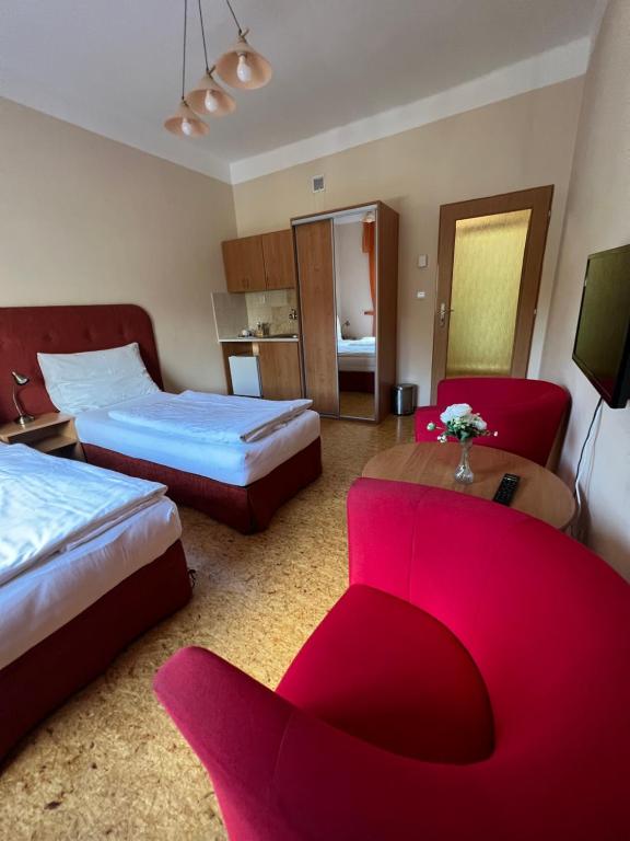 拉贝河畔乌斯季Penzion Greenstar的酒店客房带两张床和一张红色沙发