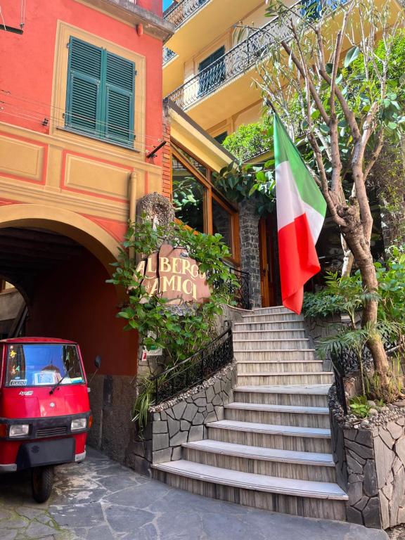 蒙特罗索阿尔马雷艾尔伯格德洋米奇酒店的停在有旗帜的建筑前的红色汽车