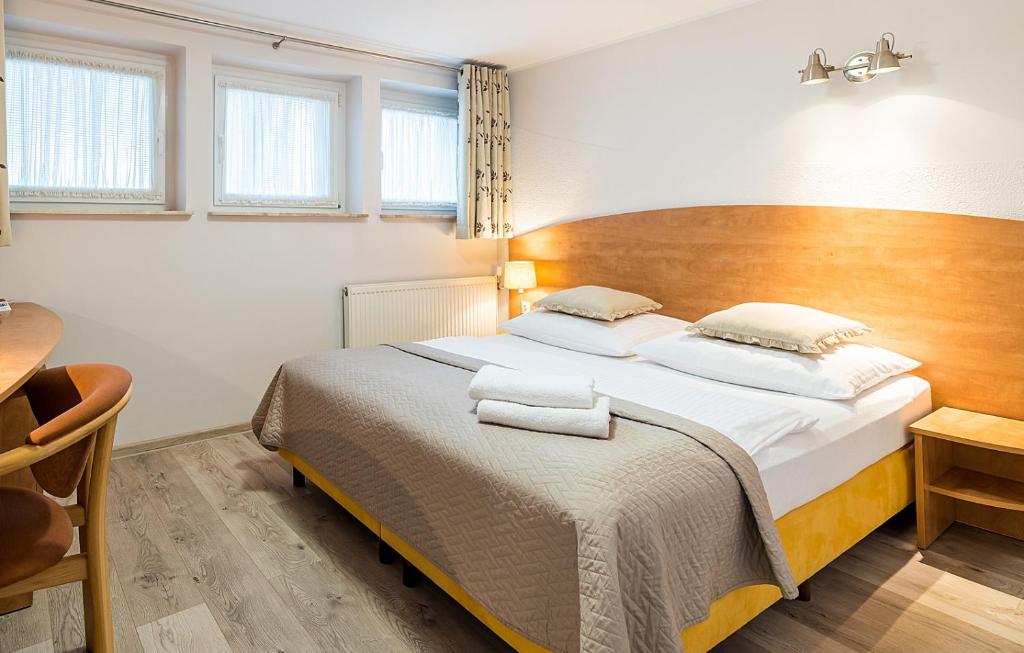 比得哥什E-Stay Noclegi w Bydgoszczy的一间卧室配有一张大床和木制床头板