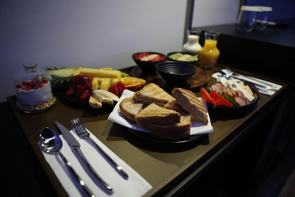 地拉那Dark Boutique Hotel的包括烤面包和水果蔬菜的早餐桌