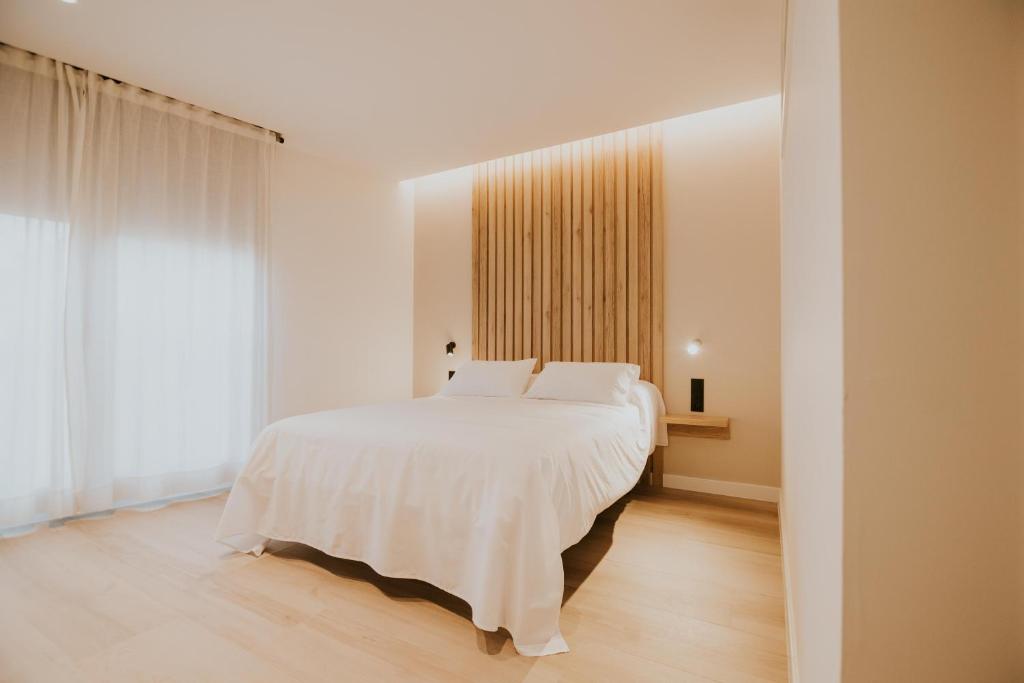 圣比森特德拉松谢拉Casa La Picuda的卧室设有白色的床和大窗户