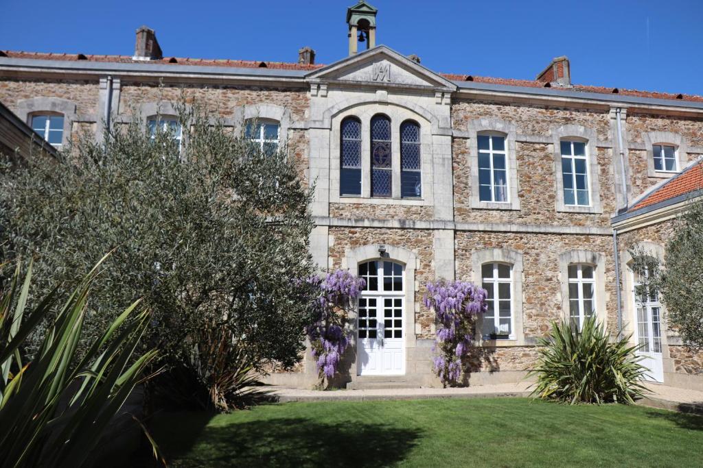 Mesnard-la-BarotièreLa Maison D'Olivier的紫色花圈的古老砖砌建筑