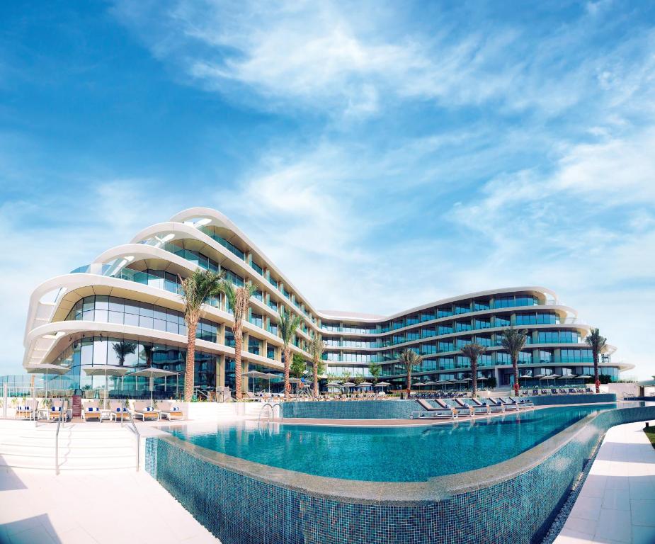 迪拜JA The Resort - JA Lake View Hotel的一座带游泳池的建筑的 ⁇ 染