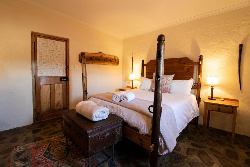 格拉夫-里内特Wild Olive Cottage的一间卧室配有一张床、两个床头柜和两盏灯。
