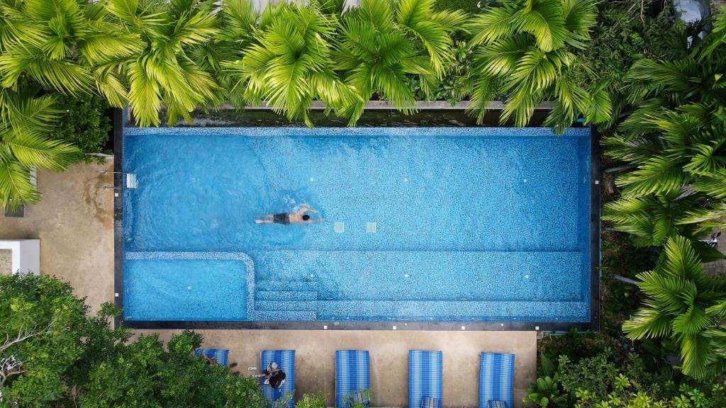芭堤雅市中心DeeProm Pattaya Hotel的游泳池游泳者上方的景致