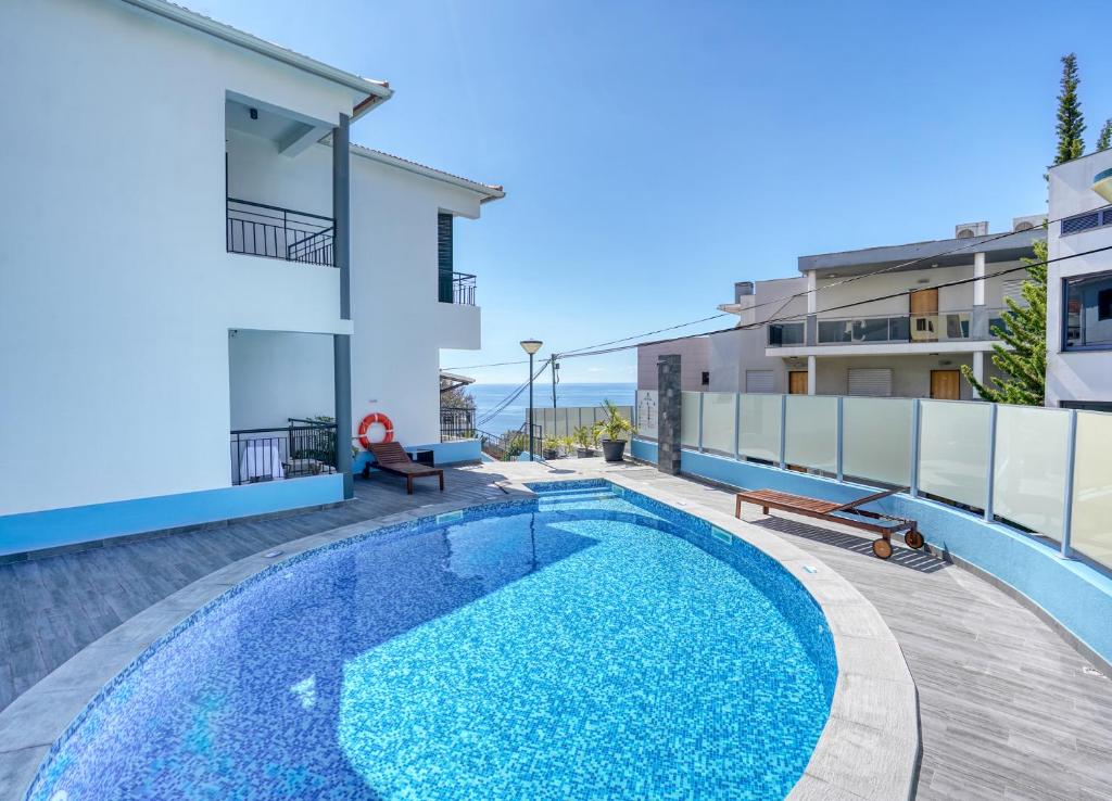 丰沙尔Vila Camacho Guest House的一座带大楼的公寓后院的游泳池