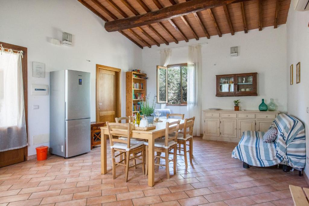 奥尔贝泰洛Agriturismo Fontetrilla的厨房配有桌椅和冰箱。