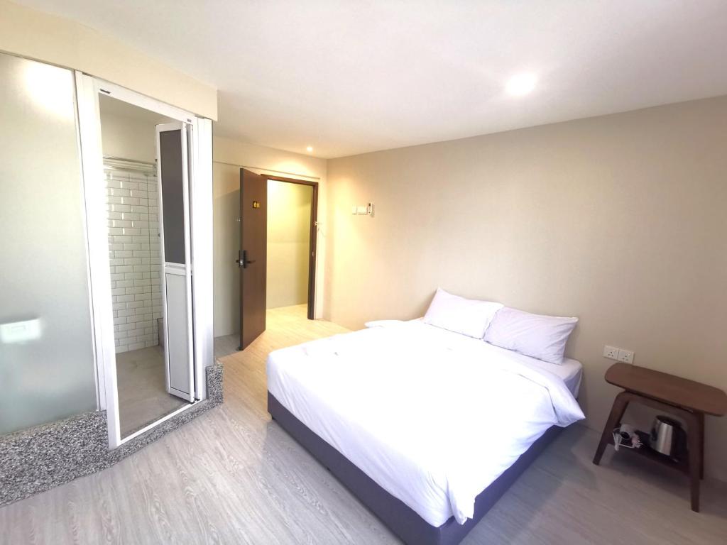 新山Maco Inn Century @Johor Bahru的卧室配有白色的床和镜子