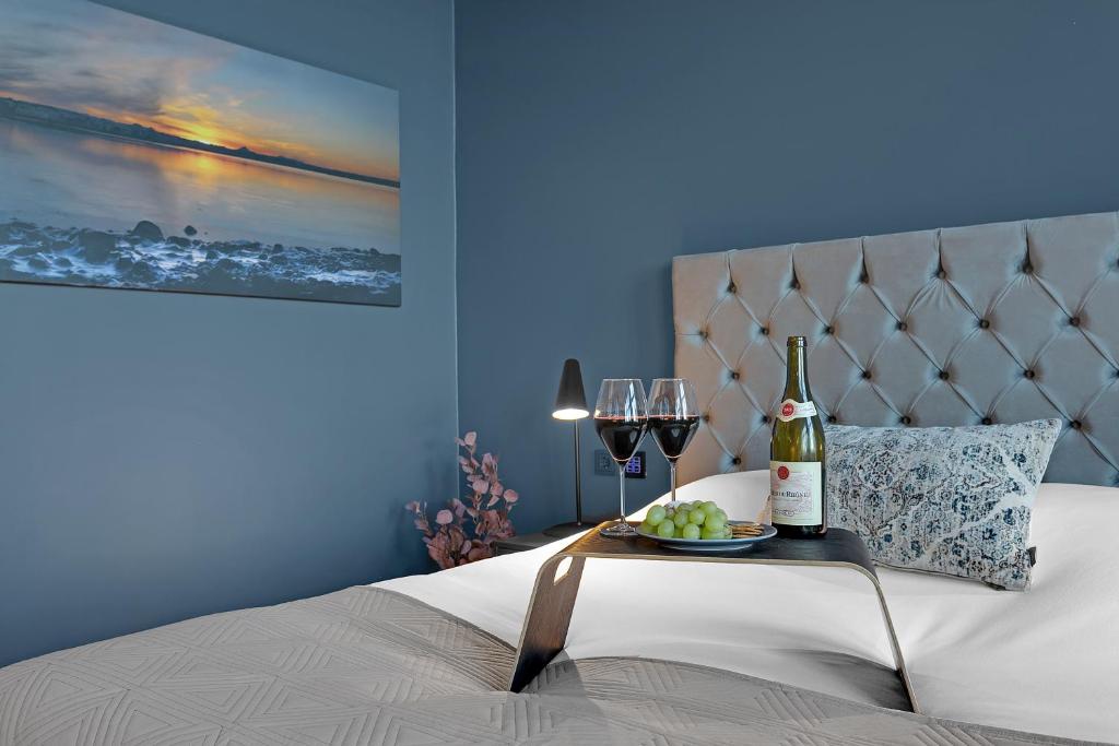 雷克雅未克Alva Hotel的一张带桌子的床铺,配有一瓶葡萄酒和眼镜