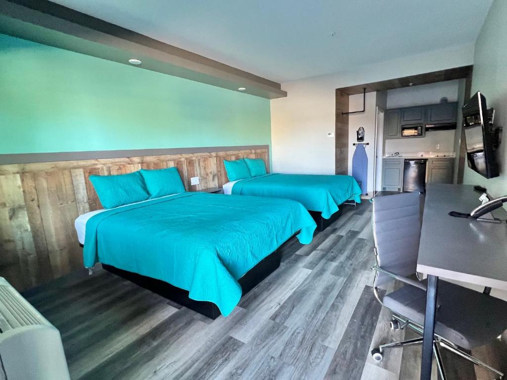 舒格兰The Residency Suites的配有蓝色床单的客房内的两张床