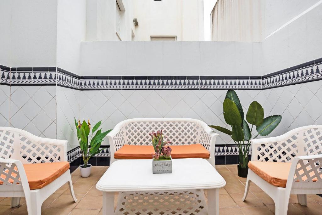科尼尔-德拉弗龙特拉Apartamento Maribel - Solo Familias的一间设有白色椅子和桌子的房间