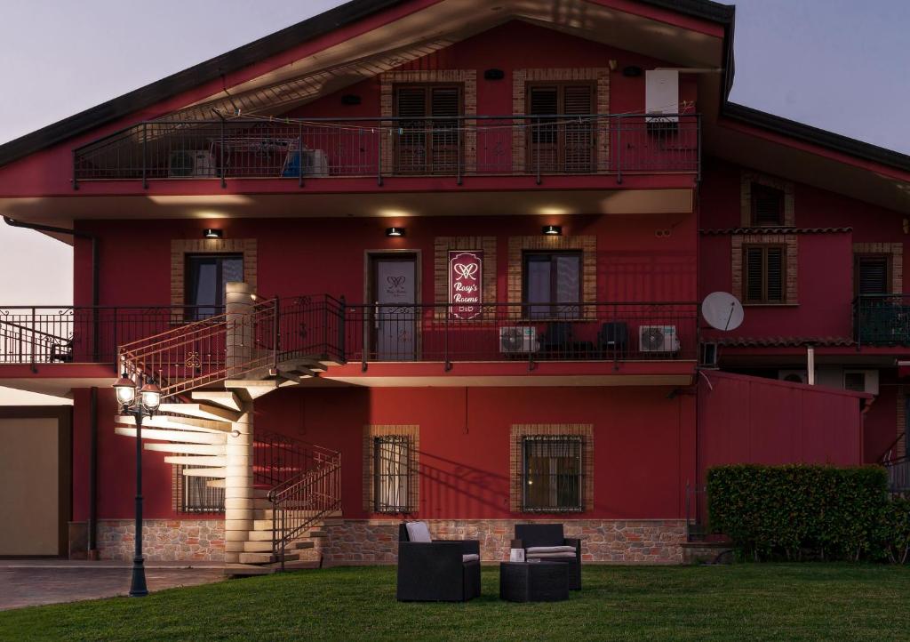 PatricaRosy's Rooms的一座红色的建筑,设有两个阳台