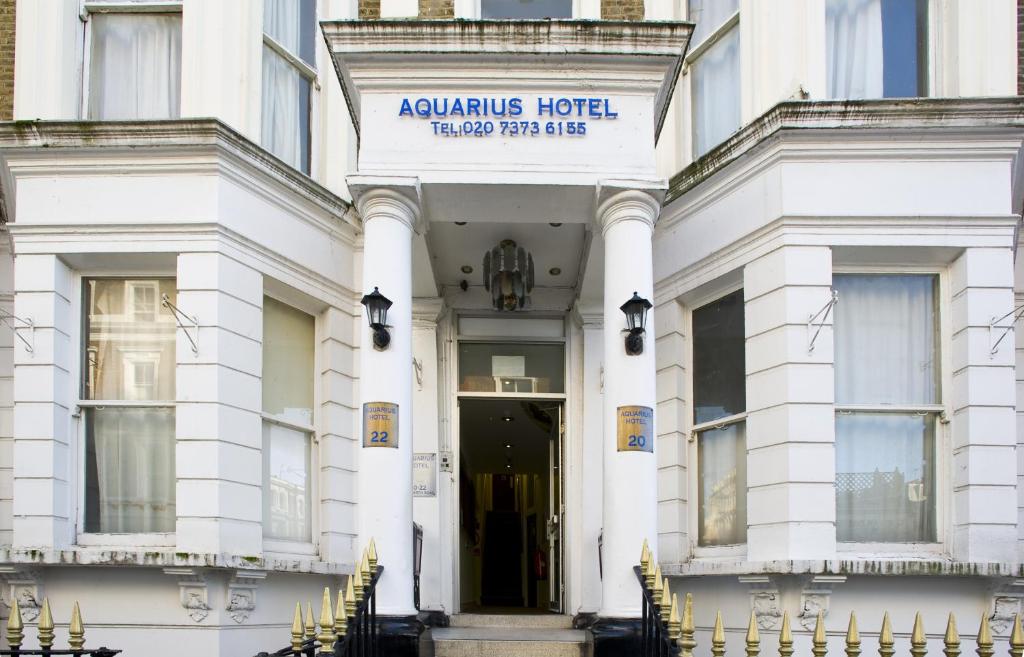 伦敦水瓶座酒店的白色的建筑,前面有标志