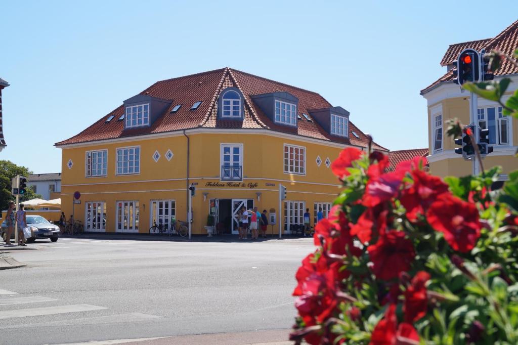 斯卡恩佛尔登斯酒店的前面有红色花的黄色建筑