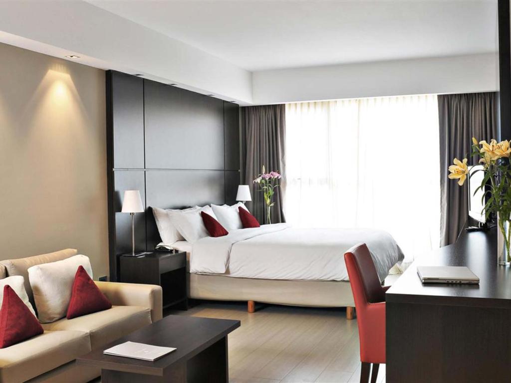 布宜诺斯艾利斯HTL City Baires的酒店客房设有一张大床和一张书桌。