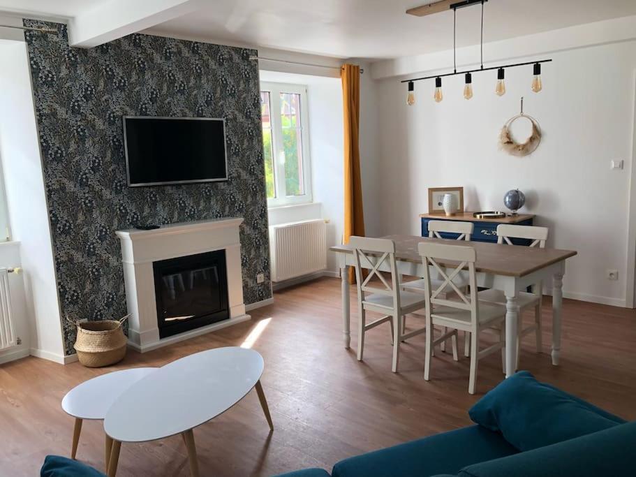 奥贝奈Le Carrousel - Appartement cosy centre Obernai的客厅配有桌子和壁炉