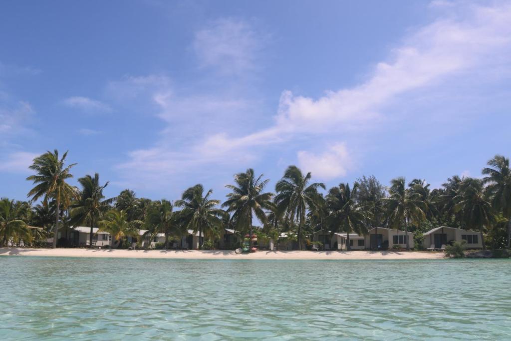 阿鲁坦加蓝姬尼斯度假酒店的享有棕榈树海滩和别墅的景色