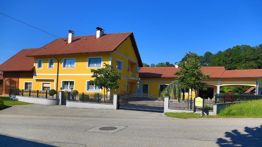 Wallern an der TrattnachFerienwohnungen Hanetseder的街上有红色屋顶的黄色房子