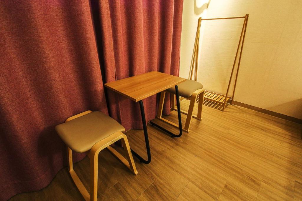 高阳市Hotel Violet的窗帘前的一张桌子和两把椅子