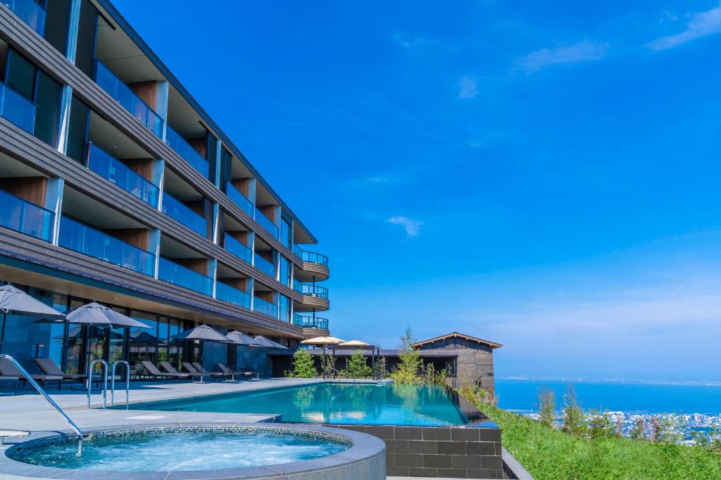 别府ANA InterContinental Beppu Resort & Spa, an IHG Hotel的一座酒店,在后面设有一个游泳池和大海