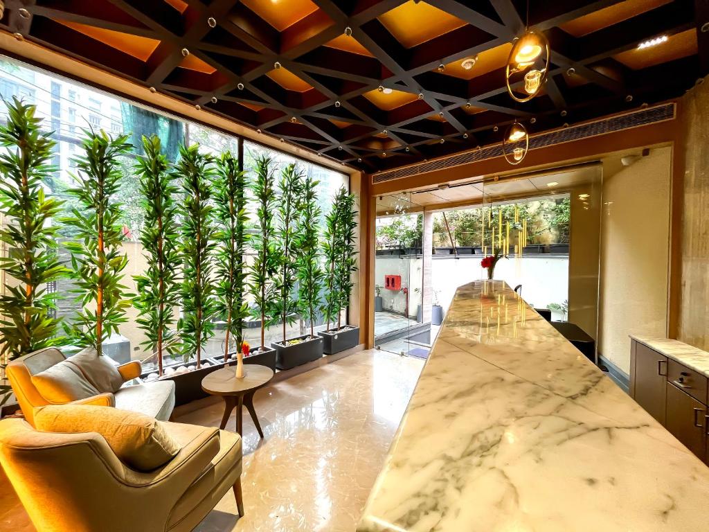 加尔各答Morvee Hotels Alipore Kolkata的大房间设有大窗户,种有植物