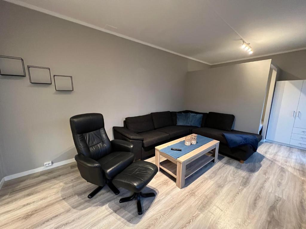 诺托登Notodden Sentrum Apartment NO 7的客厅配有沙发、椅子和桌子