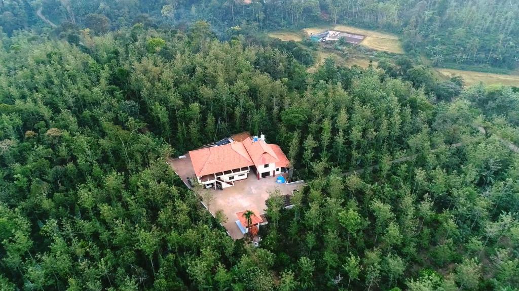 马迪凯里Coorg Bliss Estate Stay的森林中间房屋的空中景观