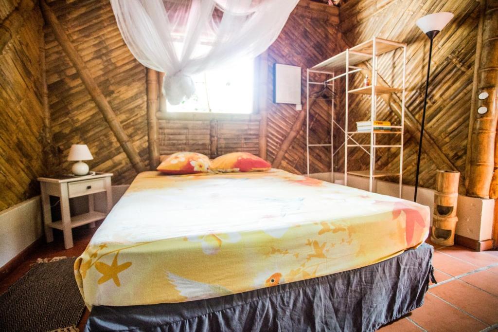 拉特里尼泰Shuit Bambou的小木屋内一间卧室,配有一张床