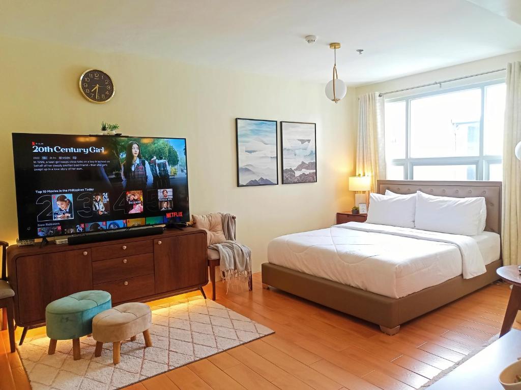 DasagPacificSuites PH的一间卧室配有一张床和一台平面电视