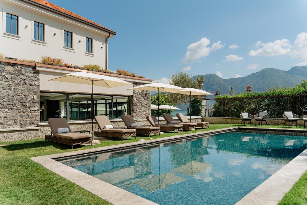 萨拉科马奇纳MUSA Lago di Como的房屋旁的游泳池配有椅子和遮阳伞