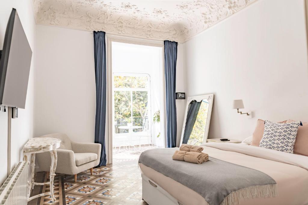 巴塞罗那B-Garden BCN的白色卧室配有一张大床和椅子