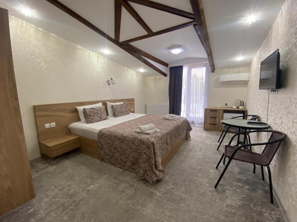 西格纳吉Hotel Traveler的一间卧室配有一张床、一张桌子和一台电视