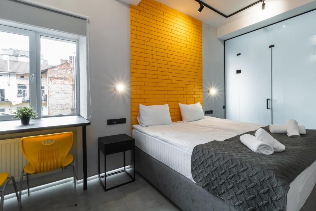 利沃夫Stories Hub的一间卧室设有一张床和黄色砖墙