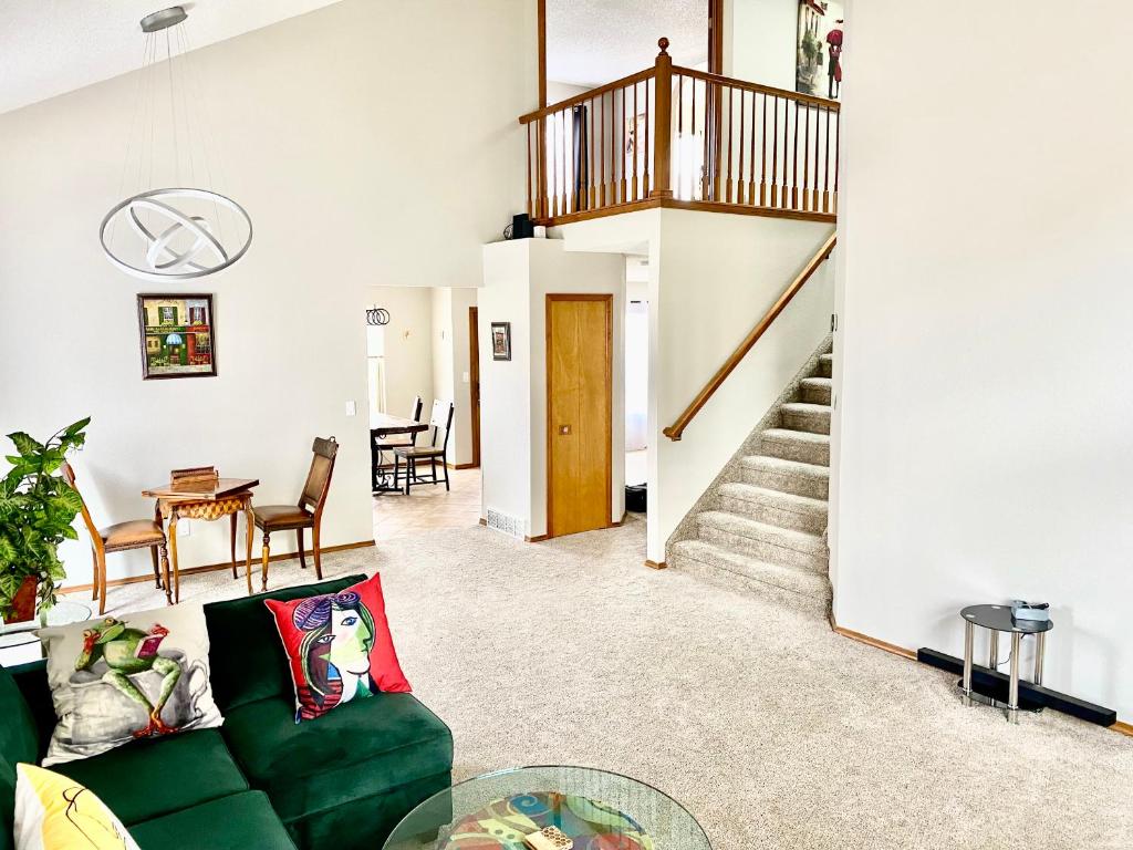 科罗拉多斯普林斯Artsy Home close to USAFA with Fireplace and Patio的客厅设有绿色沙发和楼梯。