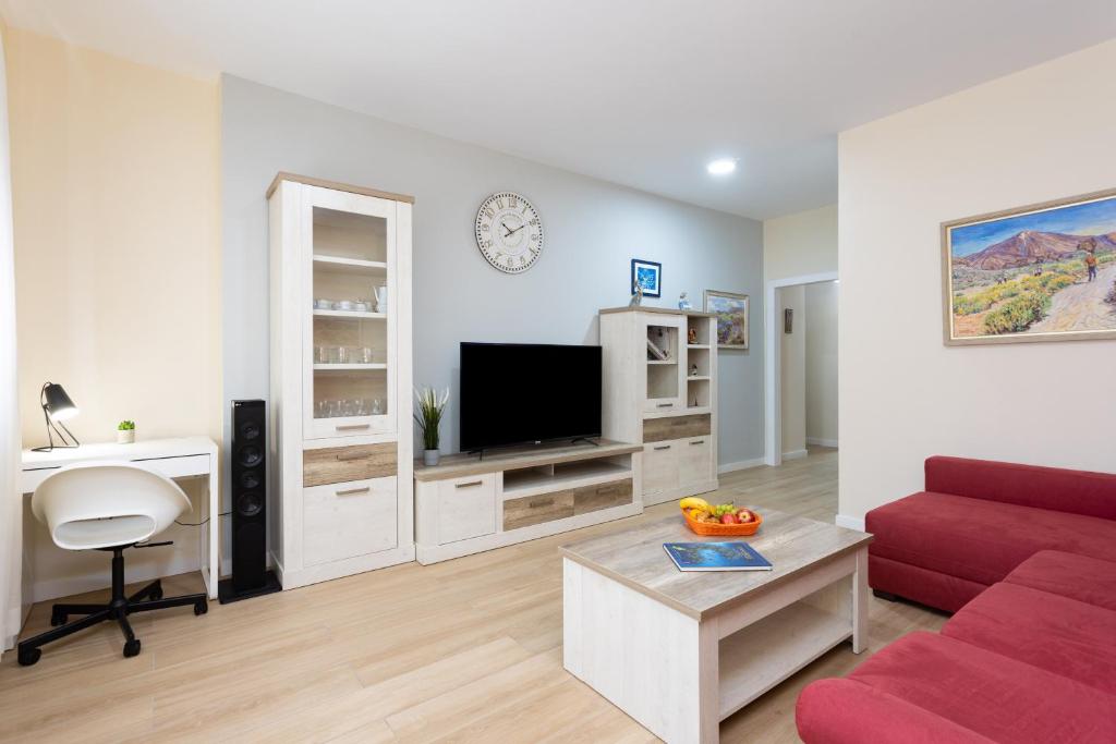 圭马尔港Home2Book Charming Apartment Puertito de Güímar的客厅配有红色沙发和电视
