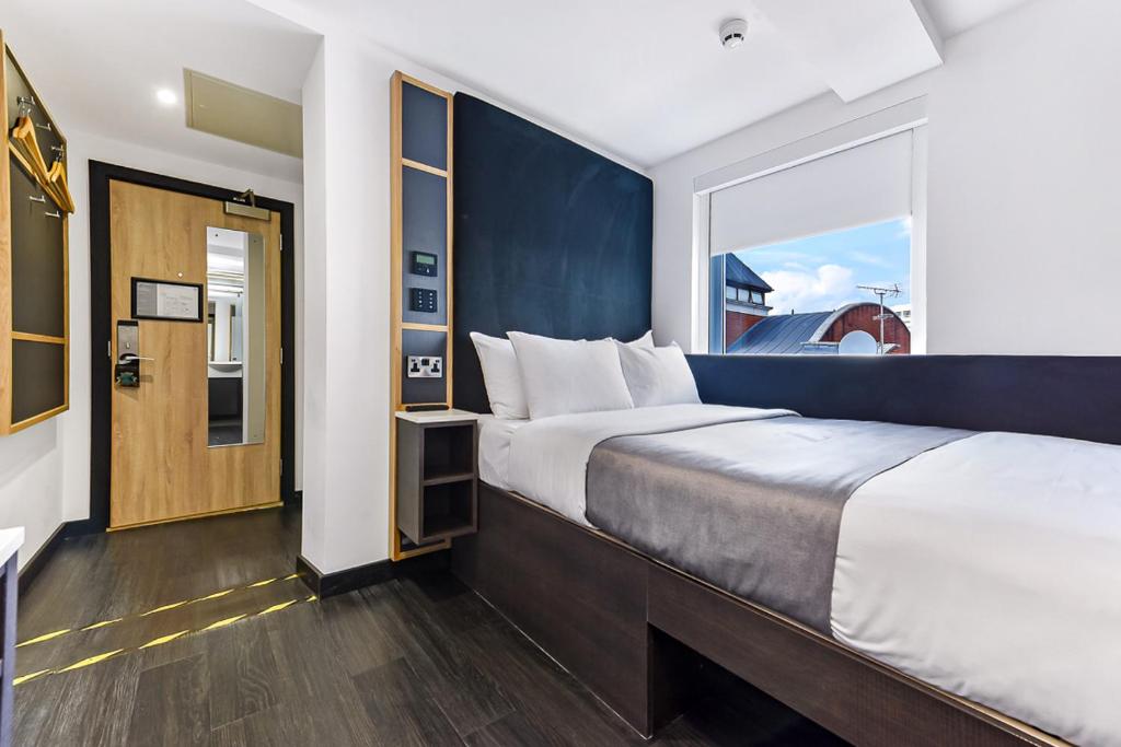 伦敦The Z Hotel Strand的一间卧室设有一张大床和一个大窗户
