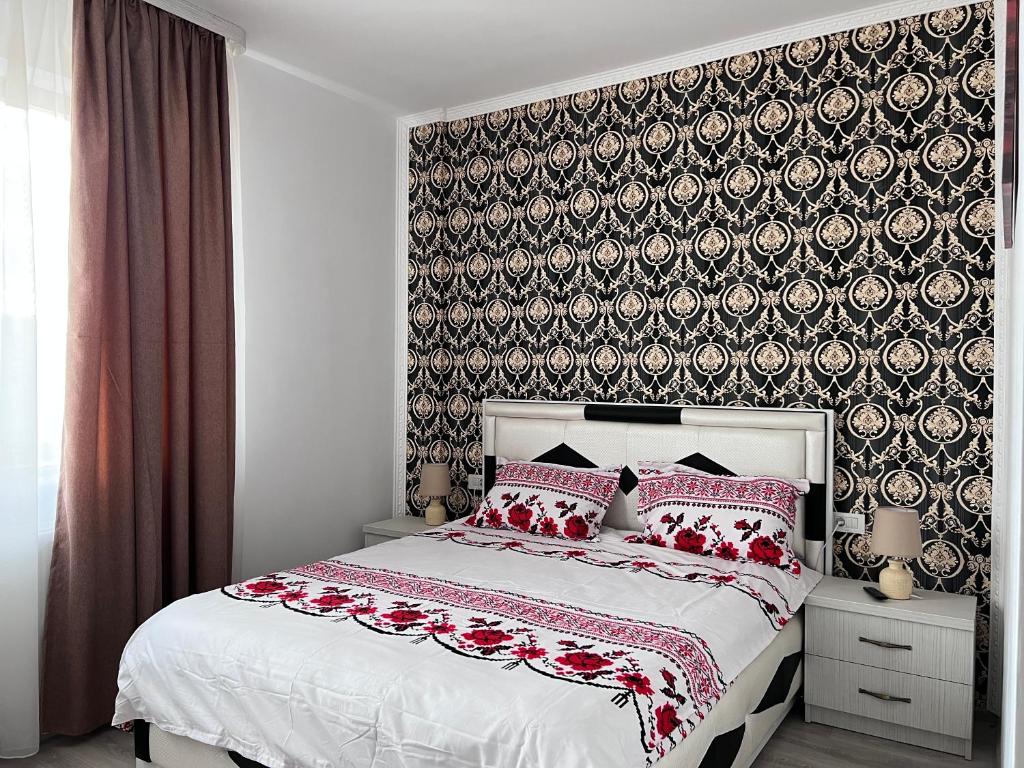 CîrceaCasa Cojocaru的一间卧室配有一张带红色枕头的床和壁纸