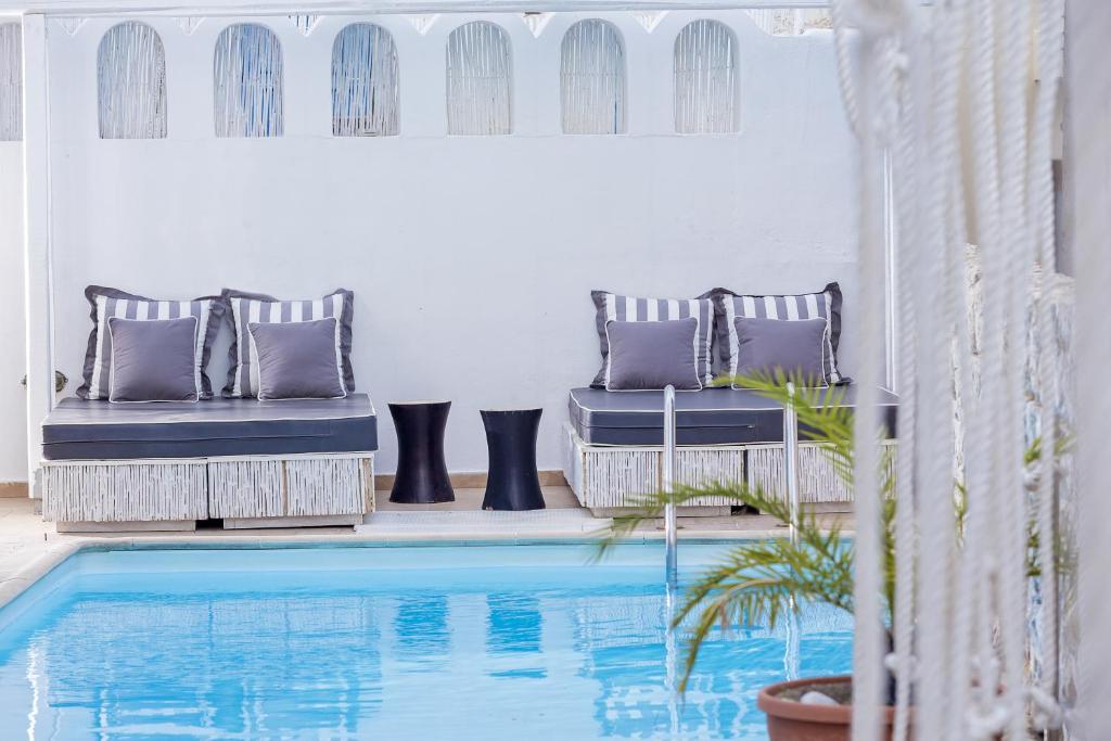 费拉洛伊索斯时尚酒店的房屋旁带两把椅子的房间的游泳池