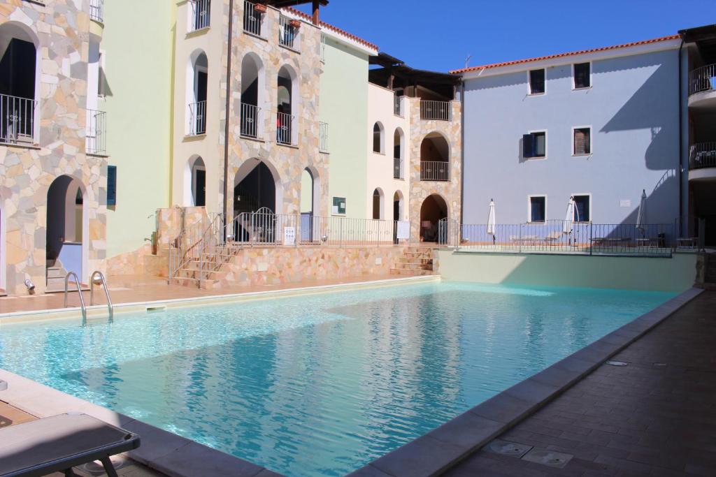 瓦雷多利亚Residence Valledoria 2 int 8的庭院内的游泳池,有两栋建筑