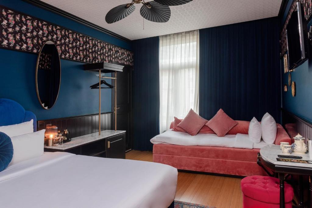 布鲁塞尔Craves的配有蓝色墙壁和红色枕头的客房内的两张床
