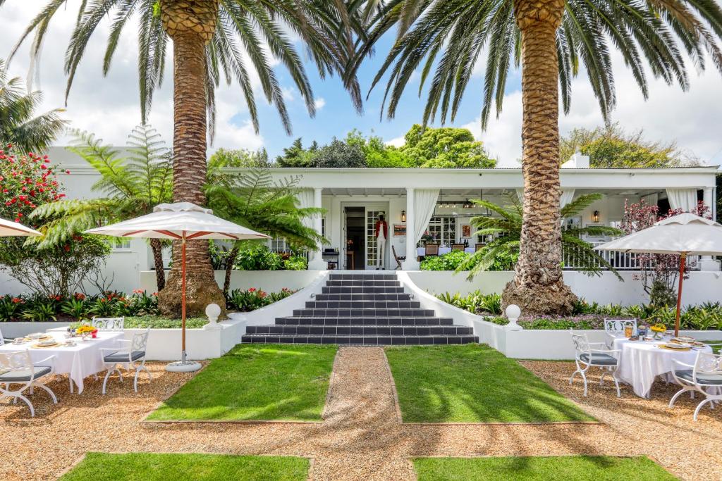开普敦Villa Coloniale Schumacher Luxury Retreat的享有度假村前方的桌子和棕榈树美景