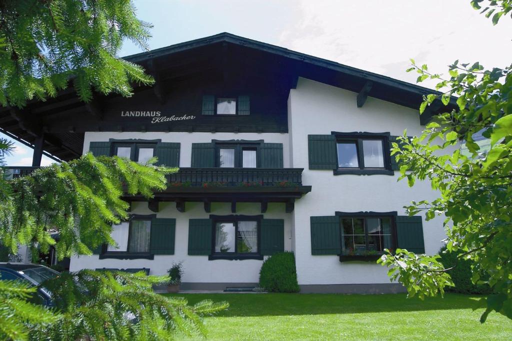 米特西尔Appartement Residenz Klabacher的白色绿色的房屋,设有绿色百叶窗