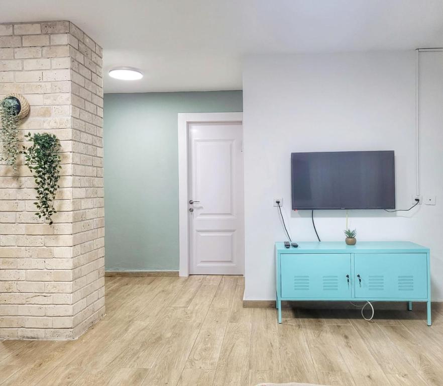 恰斯林בית בלב הגולן的客厅配有蓝色橱柜和墙上的电视