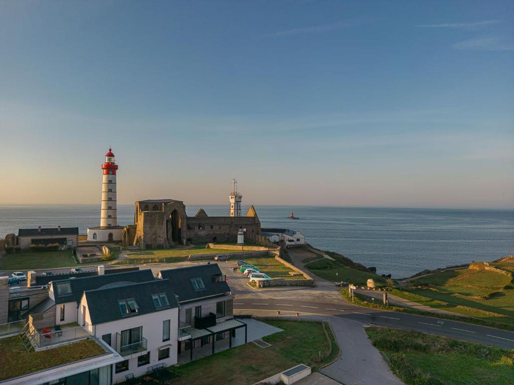 普卢贡韦兰Hostellerie de la Pointe Saint-Mathieu - SPA & Restaurant的海边山丘上的两座灯塔