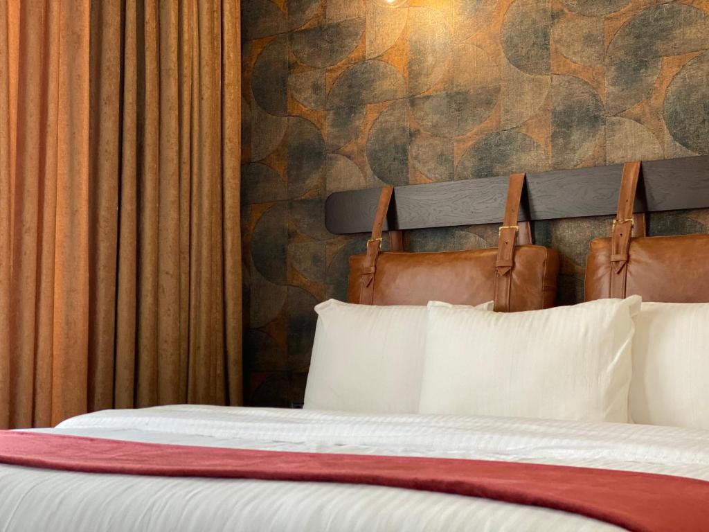 第比利斯TownHouse Tbilisi Boutique Hotel的一间卧室配有一张带两个枕头和一面墙的床。
