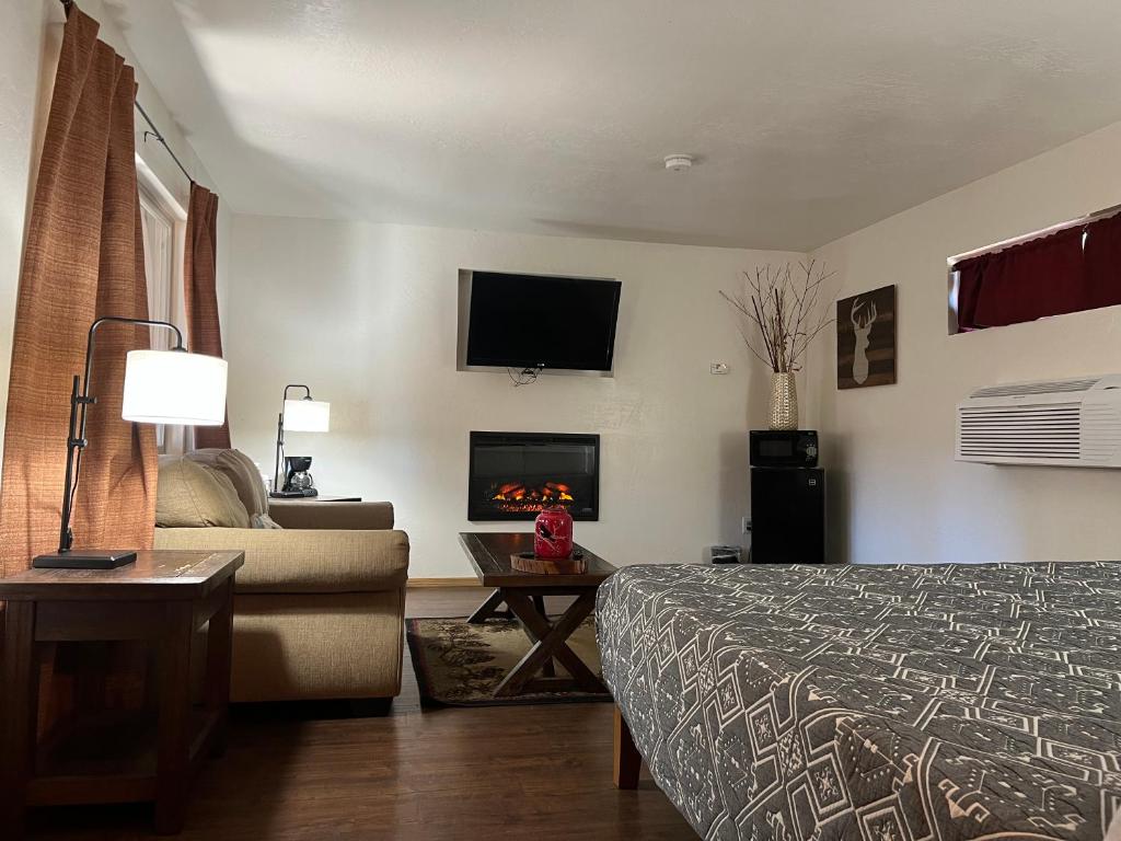 派托普湖畔木场小屋宾馆的酒店客房配有一张床、一张沙发和一个壁炉
