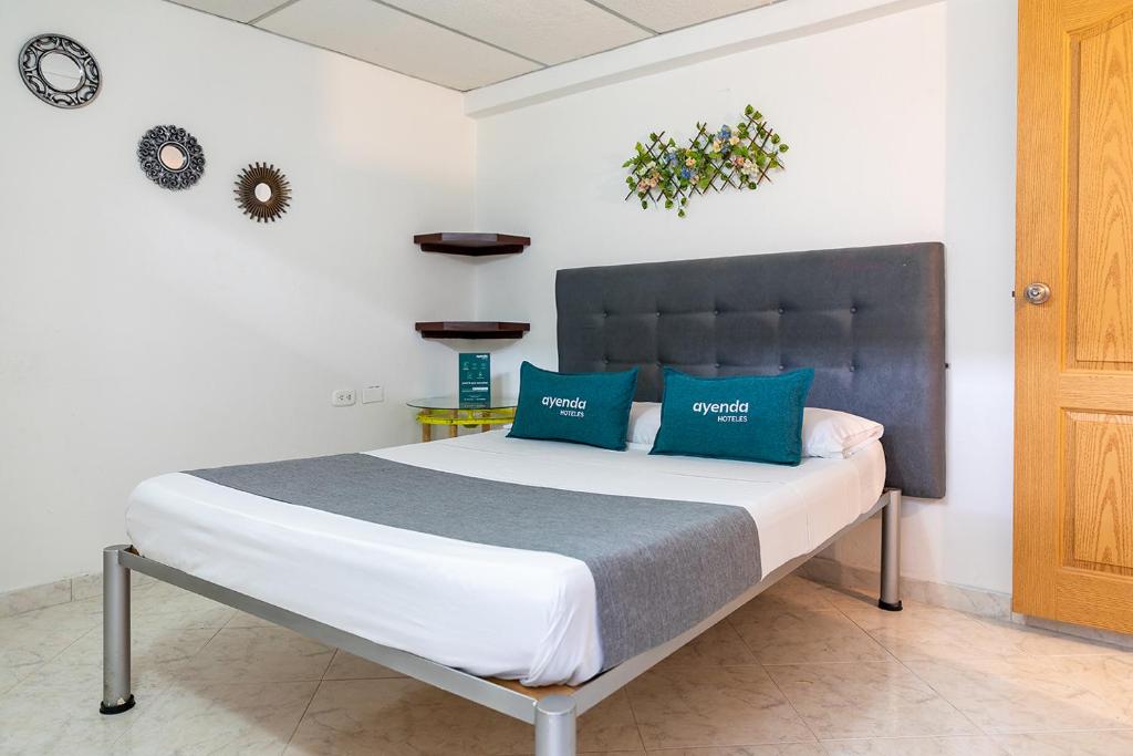 内瓦Hotel Ayenda Guadalupe的一间卧室配有一张带蓝色枕头的大床