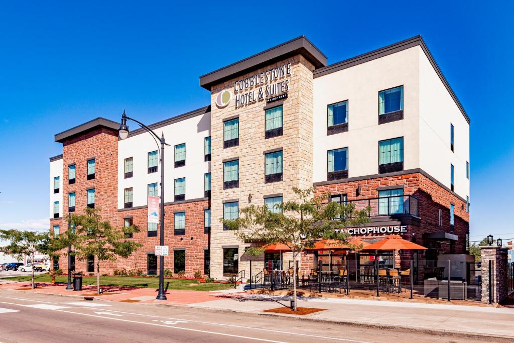 苏必利尔Cobblestone Hotel & Suites - Superior Duluth的街上一座大型砖砌建筑,设有餐厅
